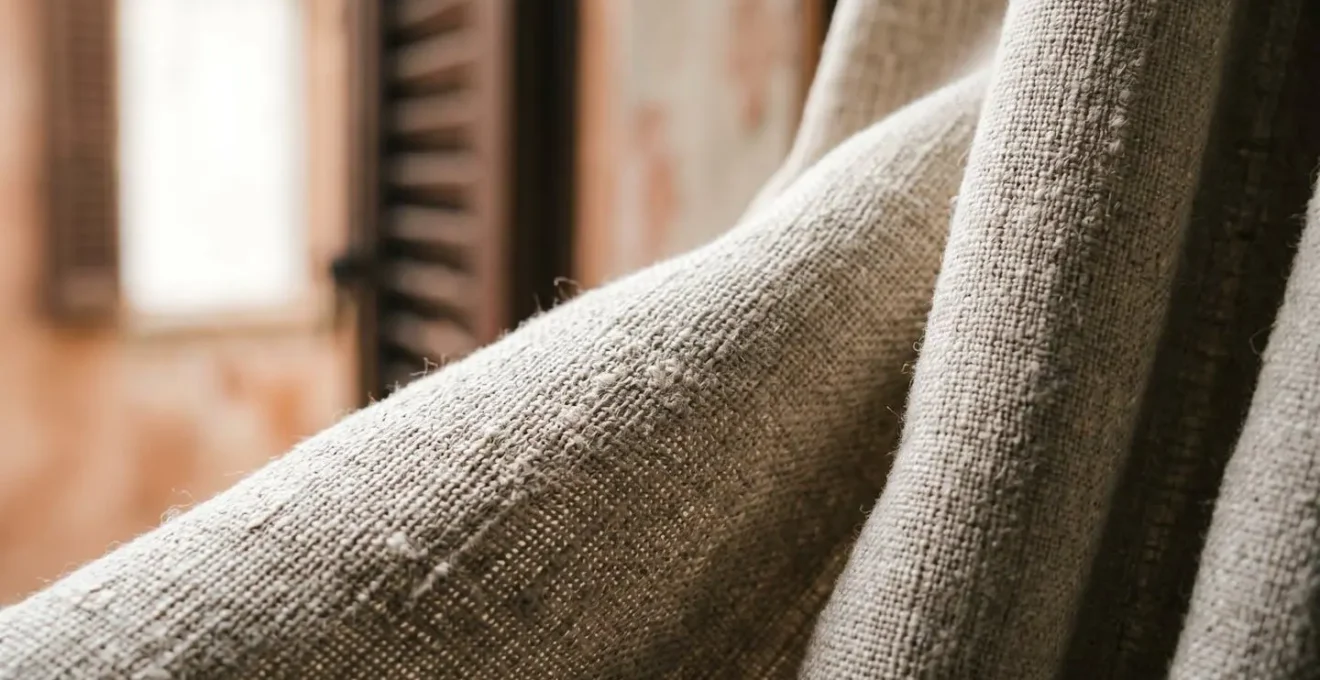 Dettaglio macro di tessuto naturale illuminato da luce soffusa di finestra che crea texture ed effetto professionale