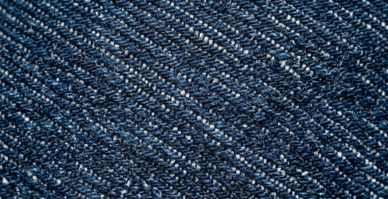 Dettaglio della texture di denim grezzo con sfumature indaco naturali