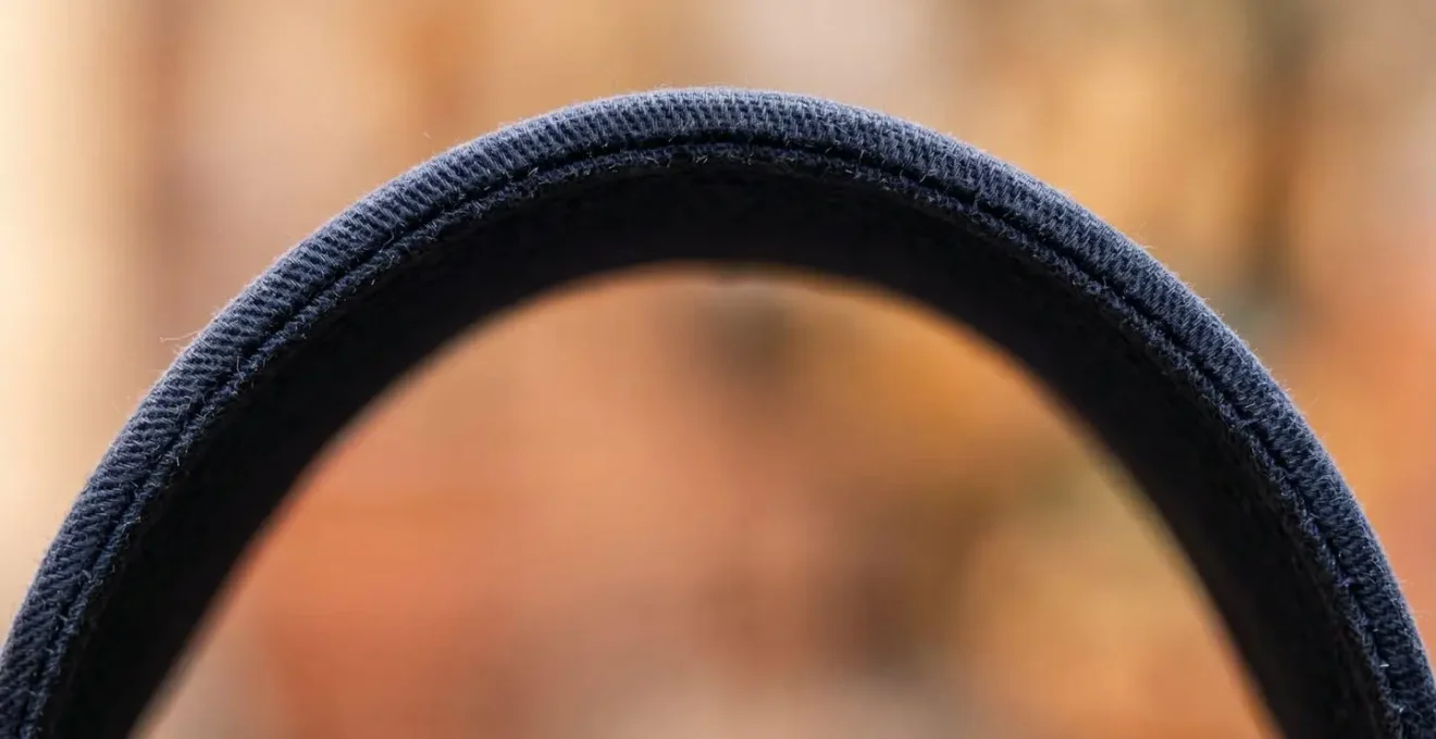 Dettaglio macro di una visiera di cappellino che crea ombra e privacy in ambiente urbano affollato